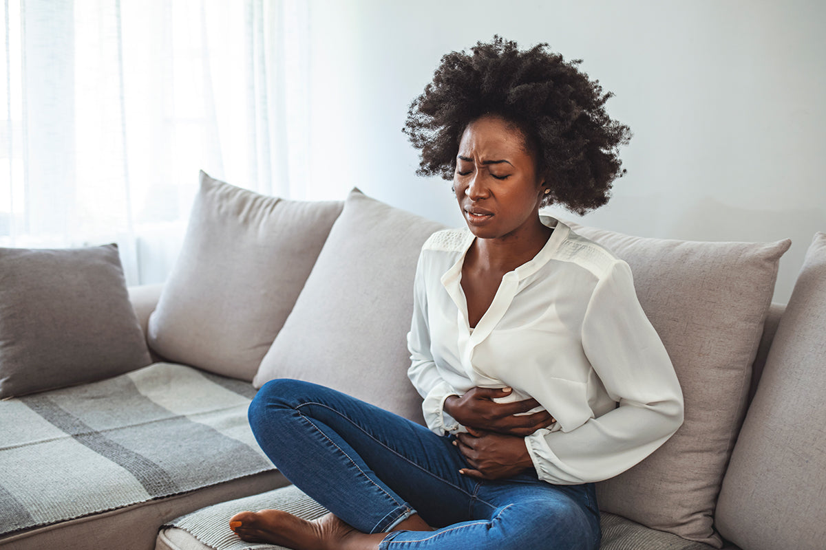 http://hellotushy.com/cdn/shop/articles/woman-holding-stomach-in-pain-couch.jpg?v=1626970000