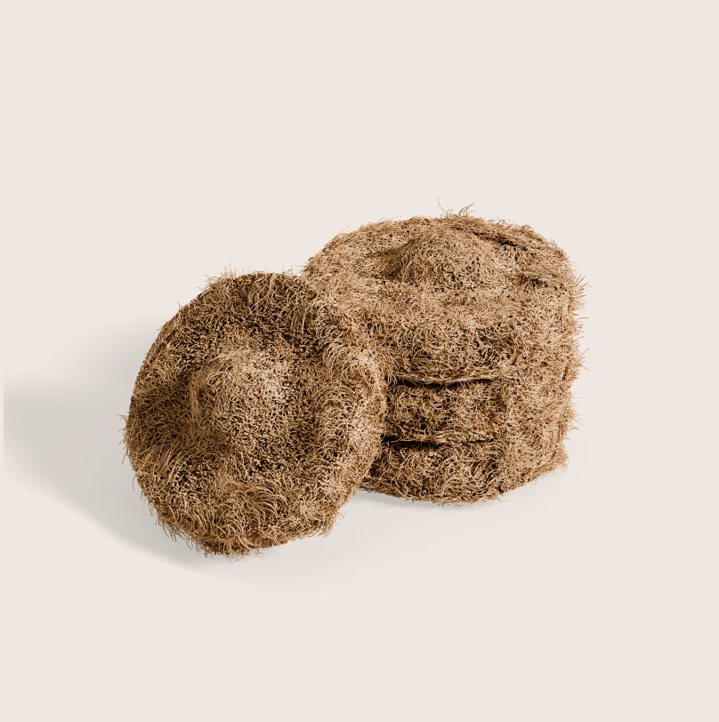 Stack of 3 coconut husk scubbing pads and one extra leaning against the stack