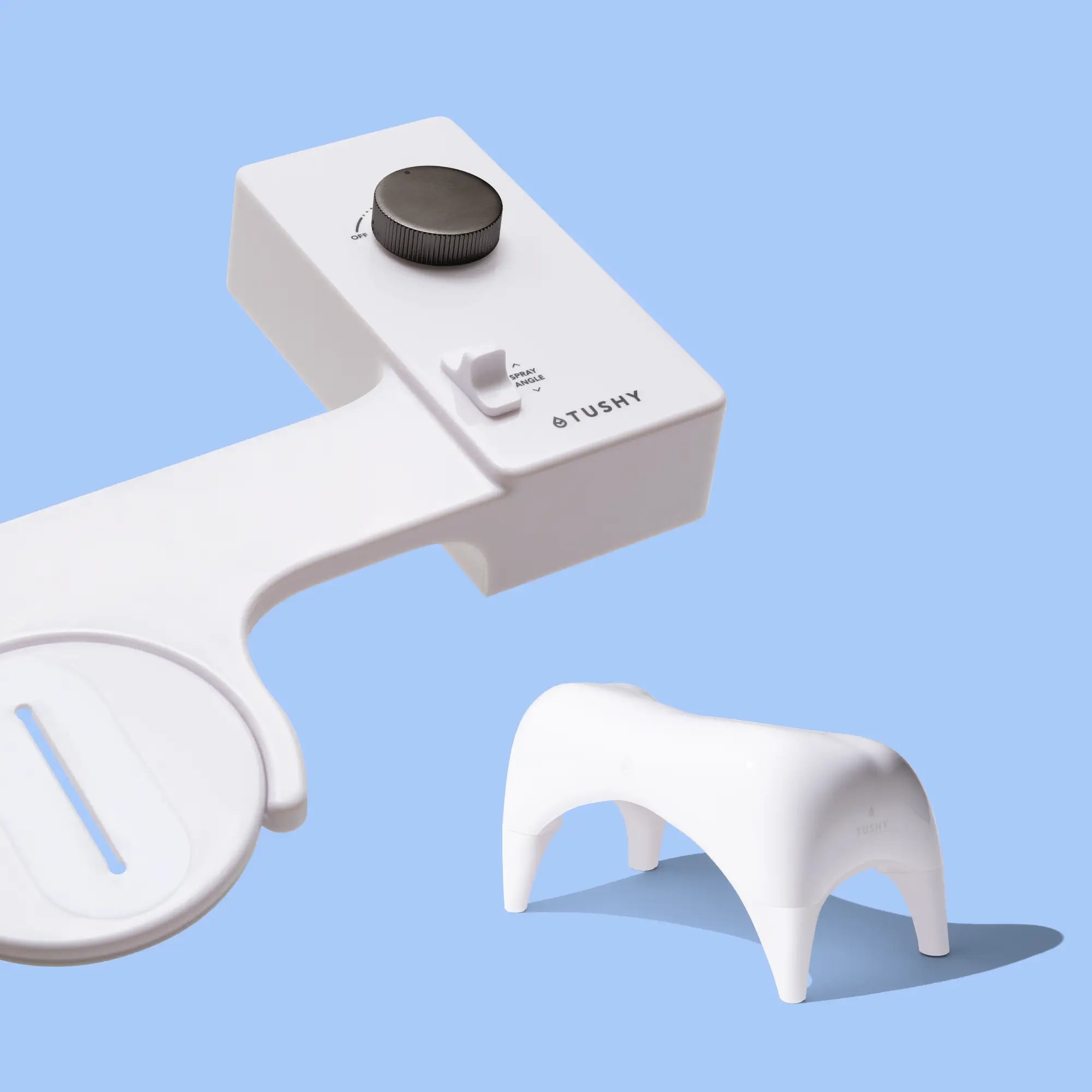 White 'TUSHY' Classic console, with a gunmetal pressure control knob, and a white Tushy Ottoman, on a light blue background