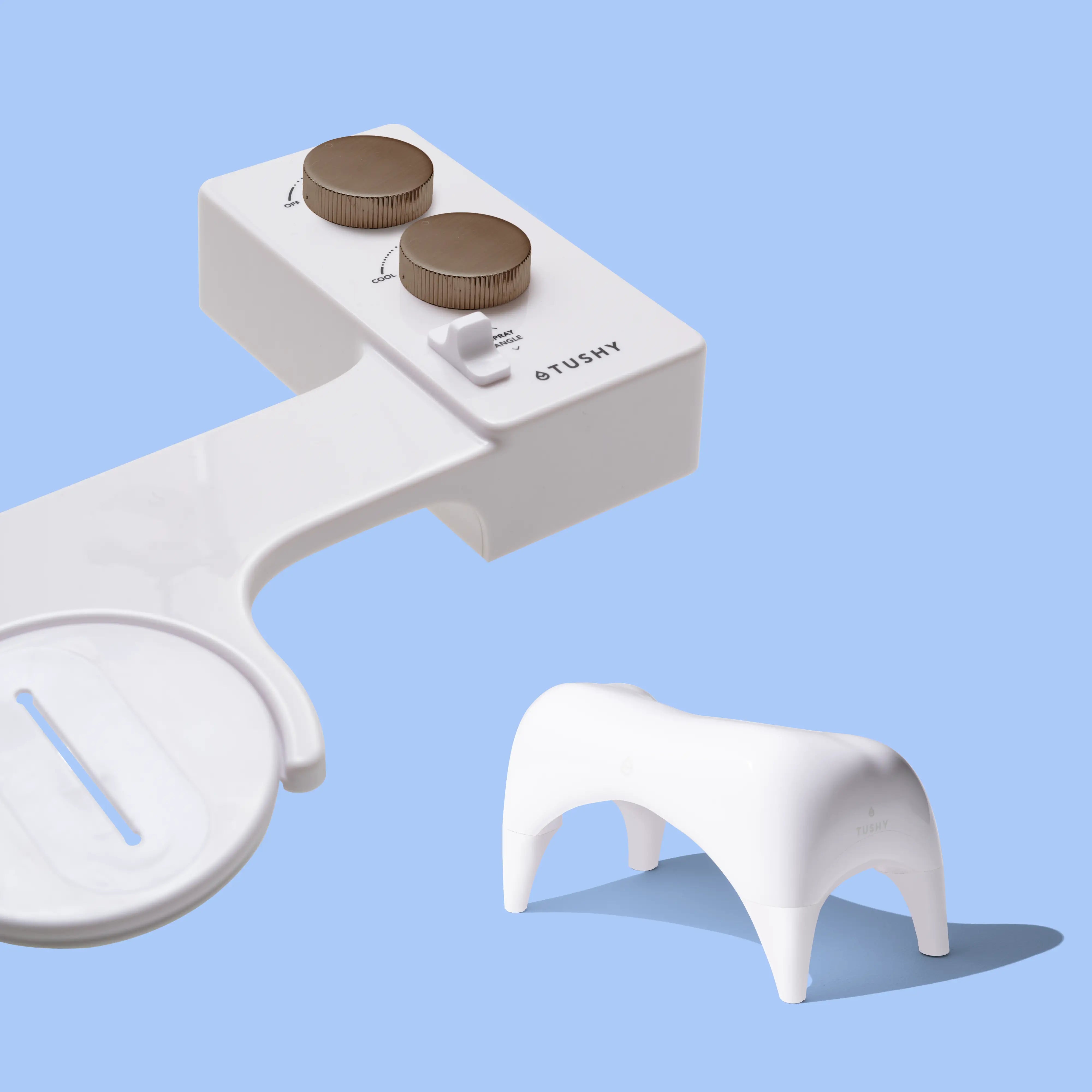 White TUSHY Spa console with 2 bronze knobs, and a white ottoman, on a blue background