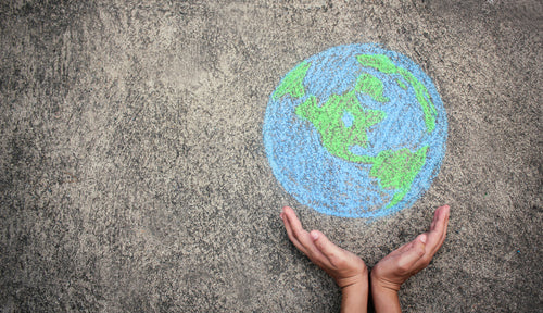 Hands with chalk drawing of Earth
