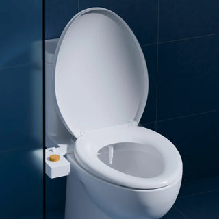 Moody blue bathroom with a TUSHY classic mounted on a white toilet 