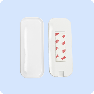 White remote mounting dock with adhesive backing, designed for secure attachment.