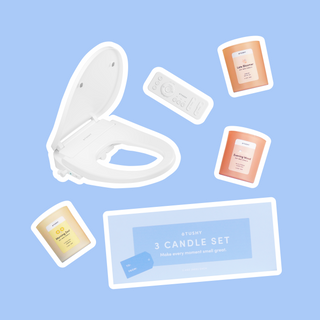 White bidet attachment with remote control and three scented candles on a blue background.