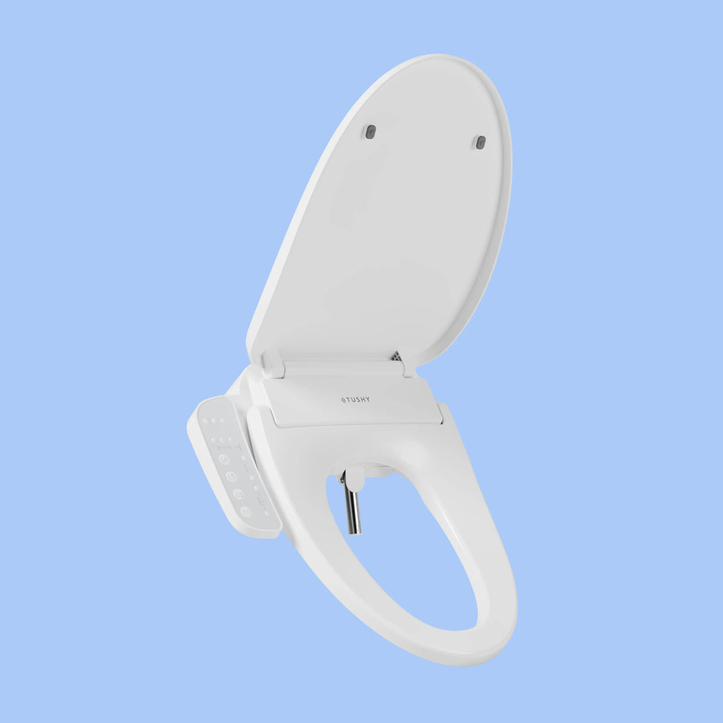 White TUSHY Cloud bidet seat, with side console control, on a blue background