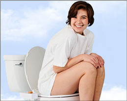 Smiling woman sitting on a toilet with a TUSHY Classic bidet attachment