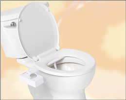 White ceramic toilet on a peach background, featuring a TUSHY Classic bidet attachment with a platinum pressure control knob