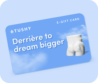 Blue TUSHY gift card that reads "Derrière to dream bigger" with a marble statue behind on a light blue background