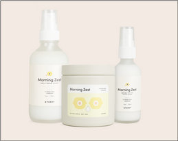 TUSHY Morning Zest scent bundle with a candle, room spray and toilet spray on a beige background