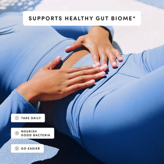 Person in blue activewear rests hands on their stomach, suggesting a focus on gut health.