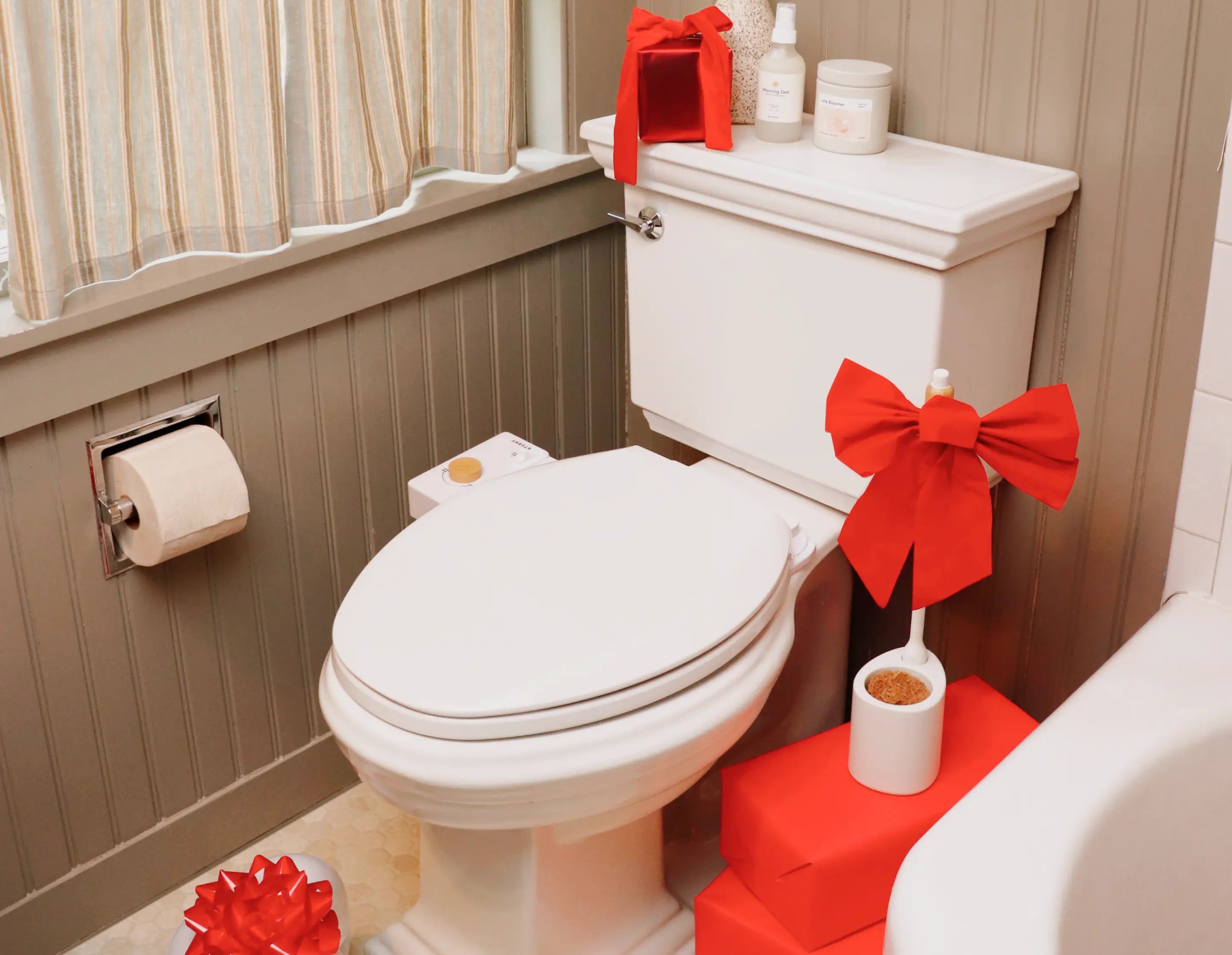 Bathroom with toilet decorated with red bows and tissues.
