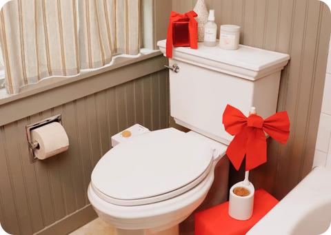 Bathroom with a toilet decorated with red bows and toiletries on the tank.