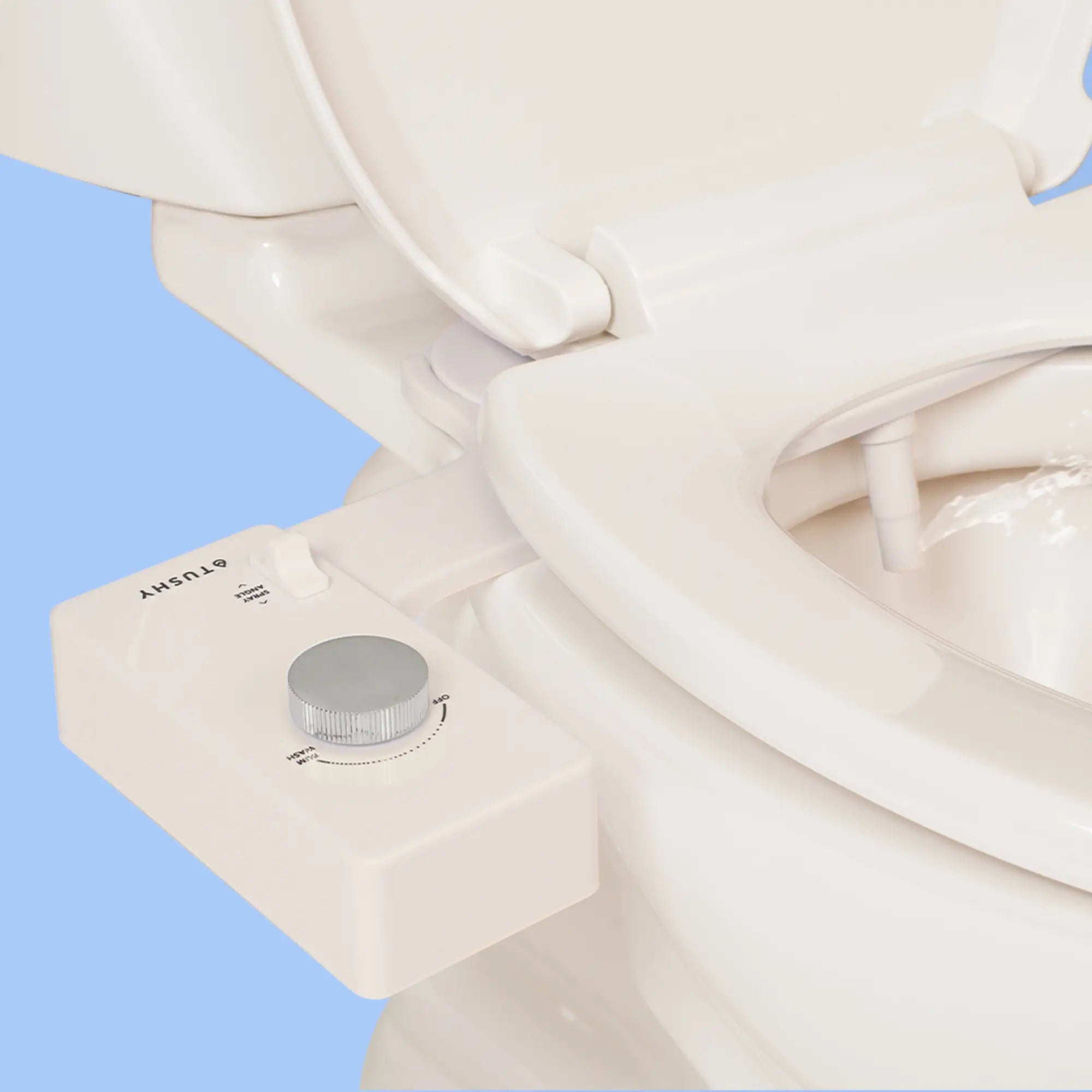 Biscuit 'TUSHY' Classic console, with a platinum pressure control knob, installed on a toilet, on a light blue background