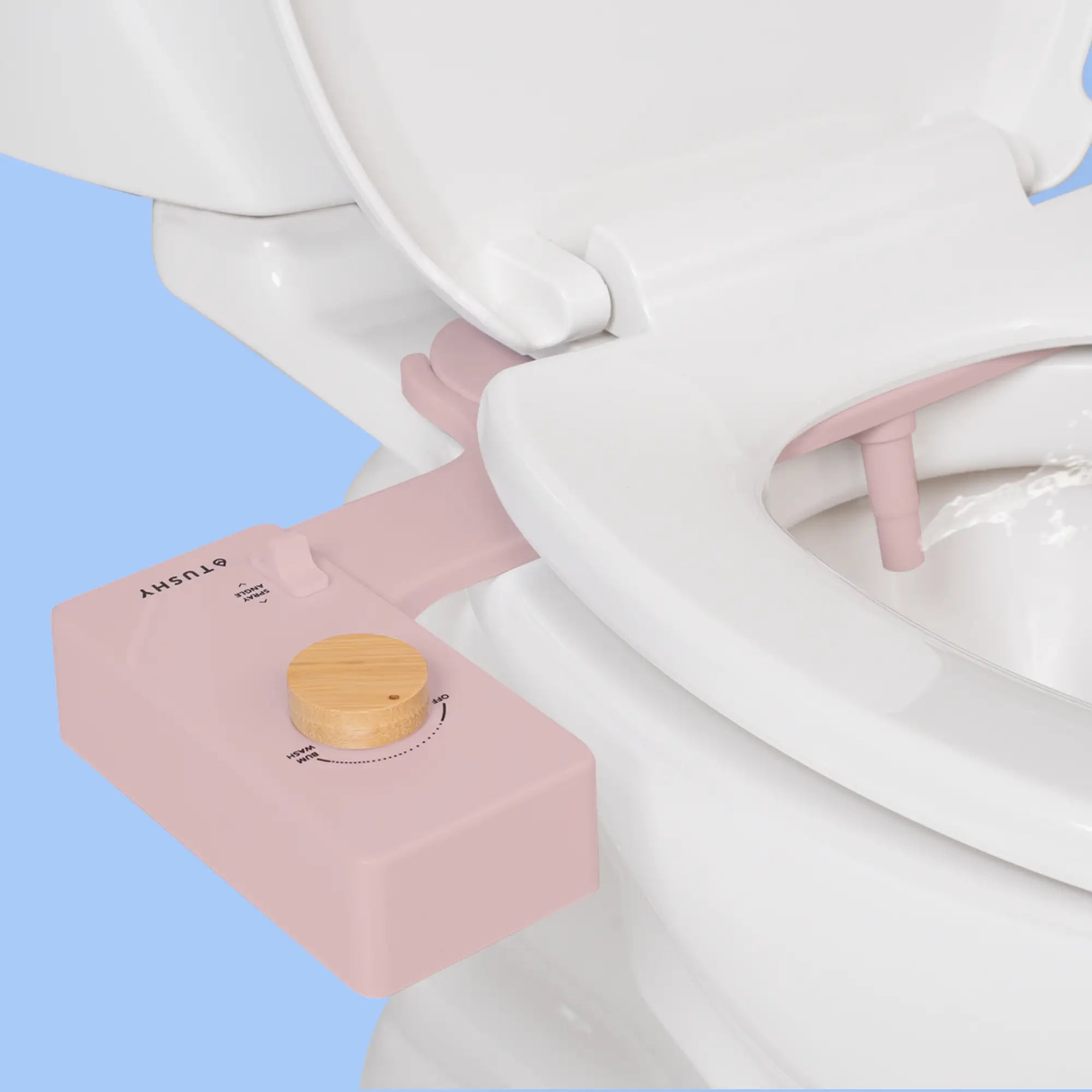 Pink 'TUSHY' Classic console, with a bamboo pressure control knob, installed on a toilet, on a light blue background
