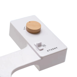 White 'TUSHY' Classic console, with a bamboo pressure control knob, on a light blue background