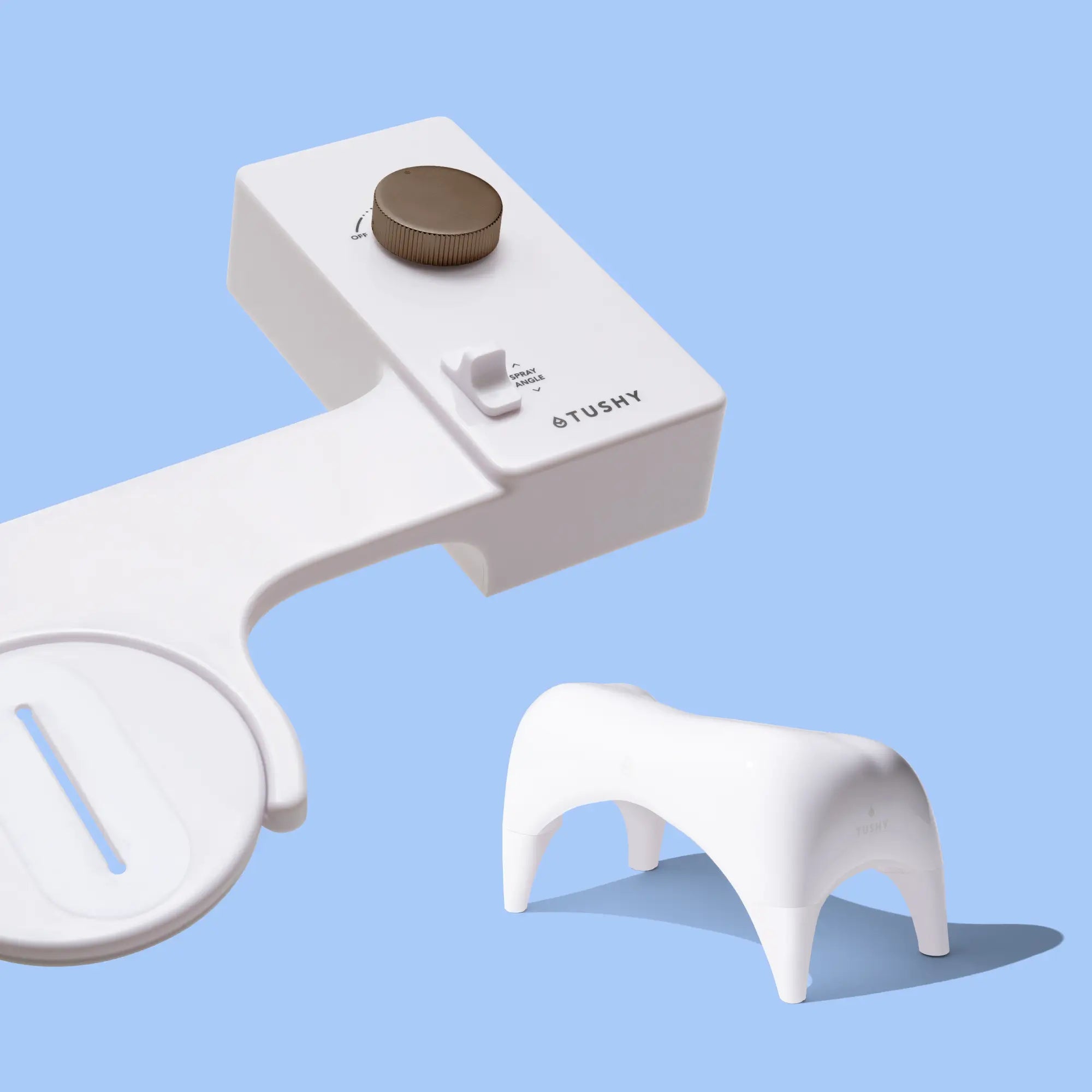 White 'TUSHY' Classic console, with a bronze pressure control knob, and a white Tushy Ottoman, on a light blue background