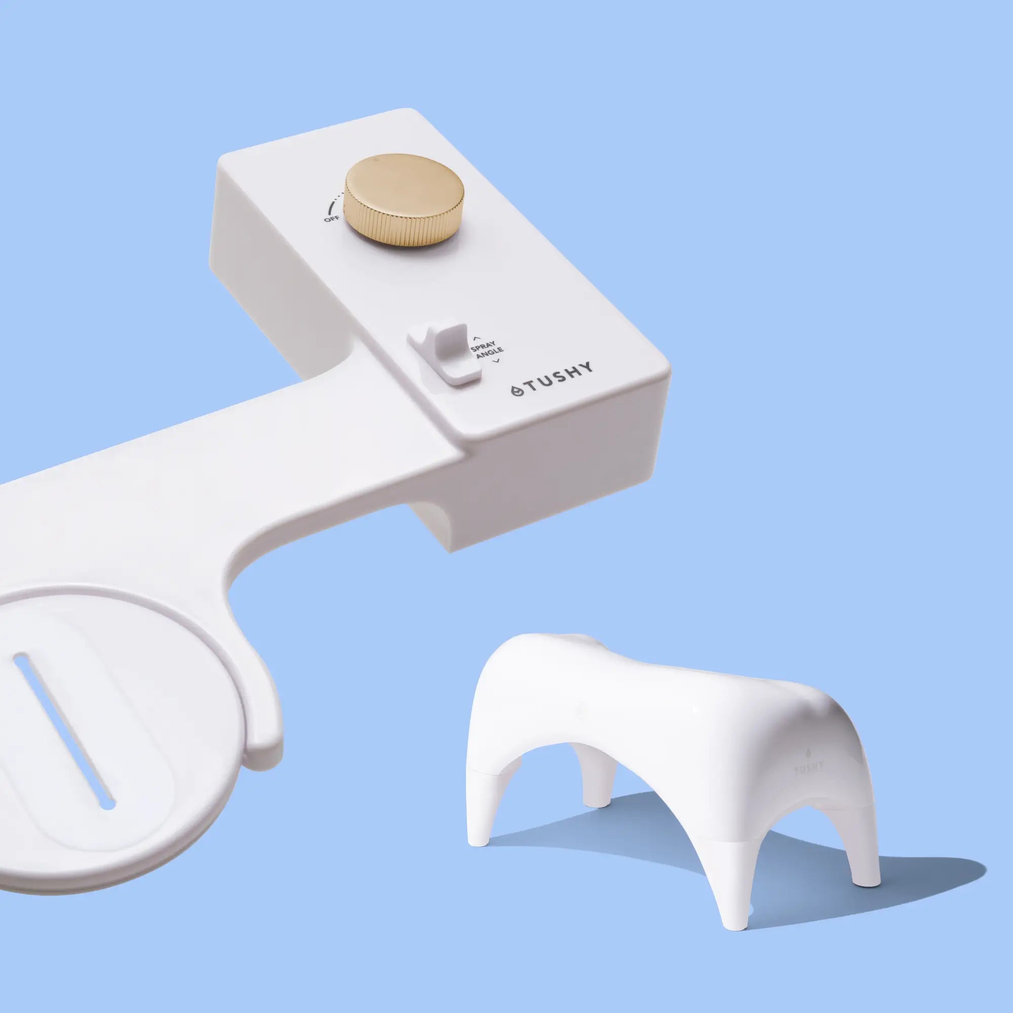 White 'TUSHY' Classic console, with a gold pressure control knob, and a white Tushy Ottoman, on a light blue background