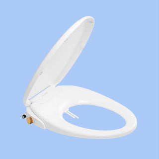 Side view White TUSHY Oasis bidet seat, with bamboo control knobs, on a blue background