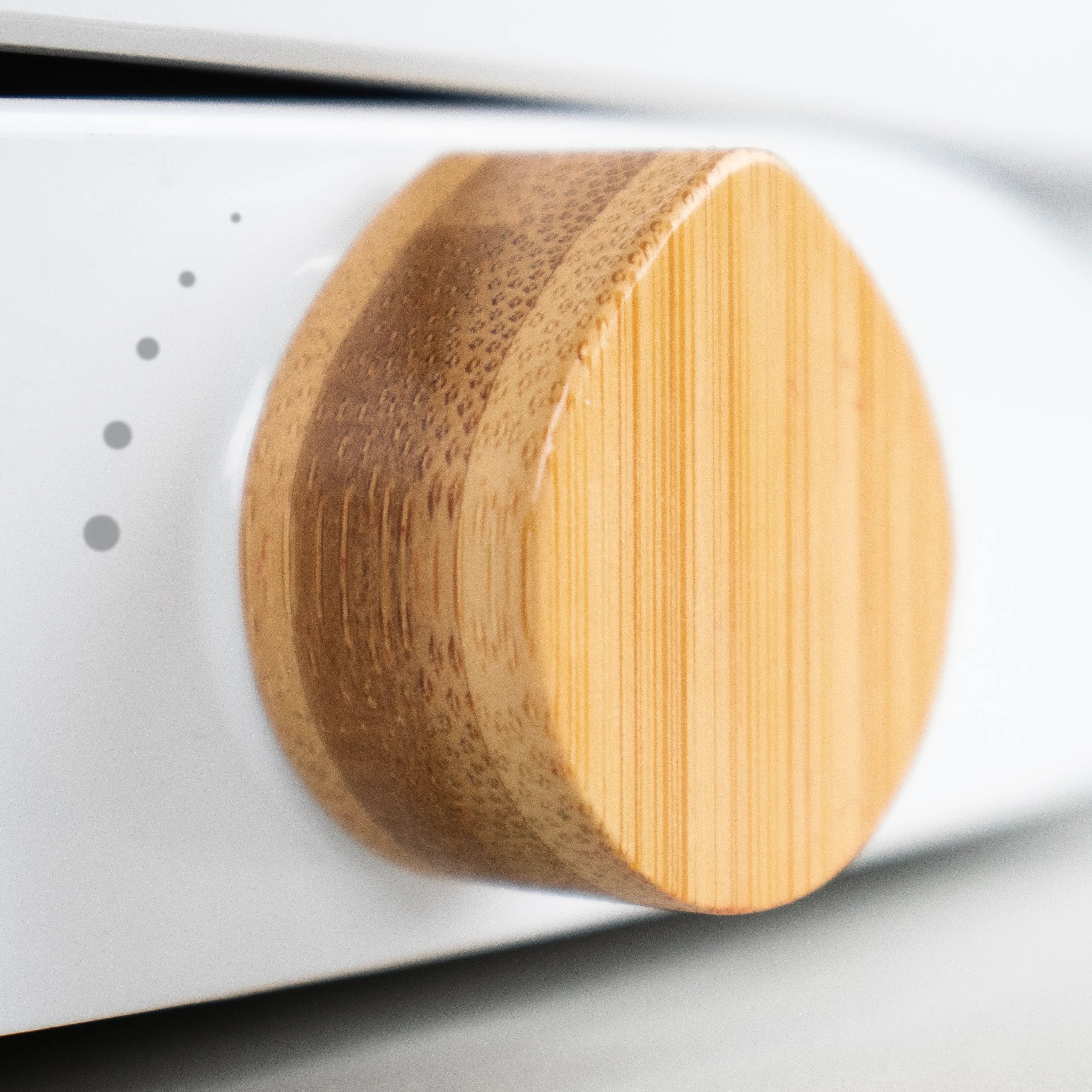 Close-up of a TUSHY Oasis bamboo control knob on a white background
