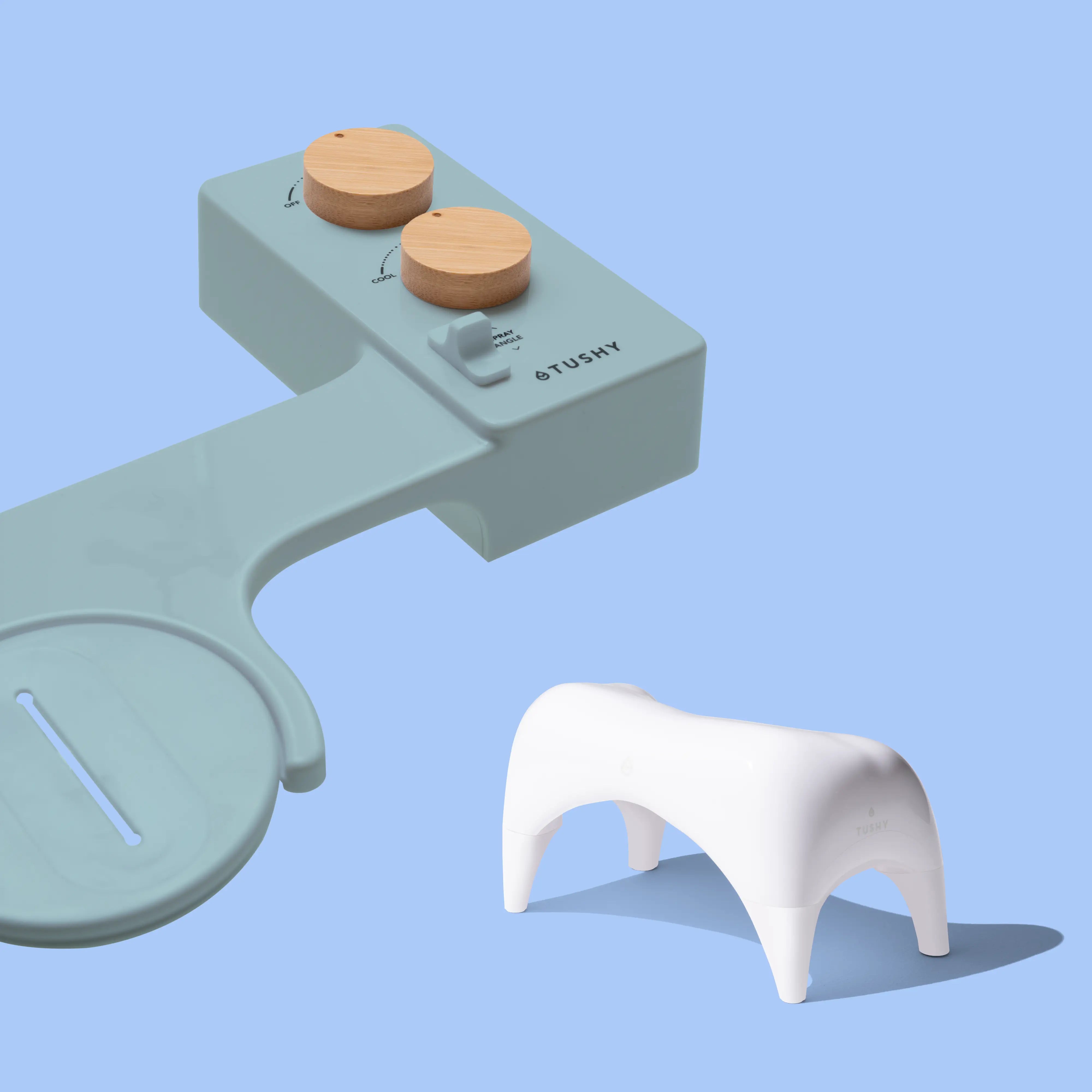 Blue TUSHY Spa console with 2 bamboo knobs, and a white ottoman, on a blue background