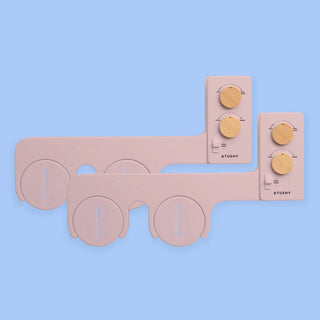 2 Pink TUSHY Spa bidet attachments, with 2 bamboo knobs, on a blue background