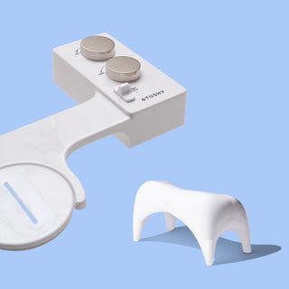 White TUSHY Spa console with 2 platinum knobs, and a white ottoman, on a blue background
