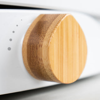 Close-up of a TUSHY Wave bamboo control knob on a white background