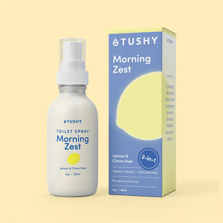 White spray bottle labeled "Toilet Spray Morning Zest" with a blue box featuring a lemon graphic and product details.