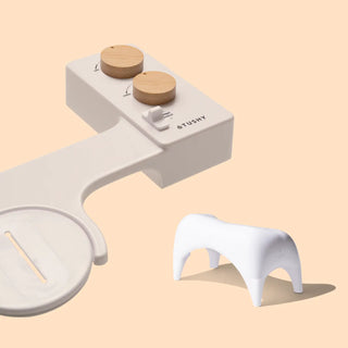 White bidet attachment with wooden knobs and a small white stool for enhanced comfort.