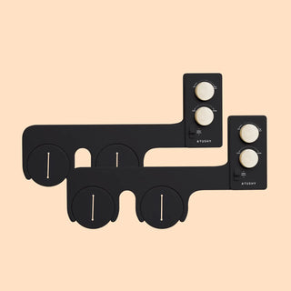 Black bidet attachment with control knobs for water pressure and temperature adjustments.