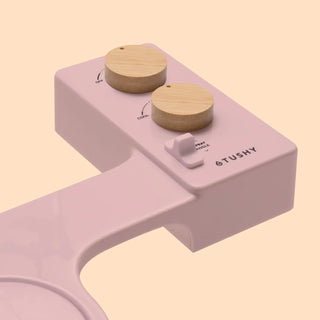 Control panel of a TUSHY Spa 3.0 bidet attachment featuring two wooden knobs and a spray angle adjustment switch.