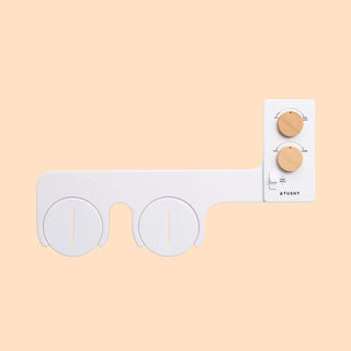 White bidet attachment with two circular controls and wooden knobs for adjusting water pressure and temperature.