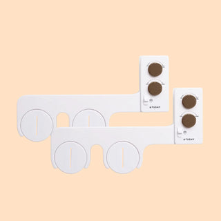 White bidet attachment with two control panels and adjustable knobs for water pressure and temperature.
