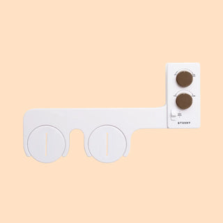 Bidet attachment with two circular nozzles and control panel featuring two knobs for water temperature and pressure.