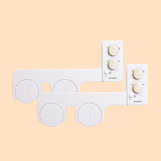 White bidet attachment with control knobs for water pressure and temperature adjustment.
