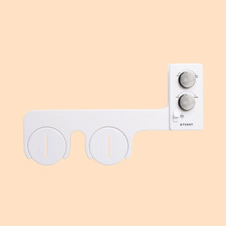 White bidet attachment with two circular nozzles and two control knobs on the side.
