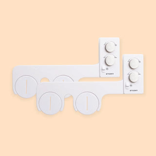 White bidet attachment with control knobs for water pressure and temperature adjustment.