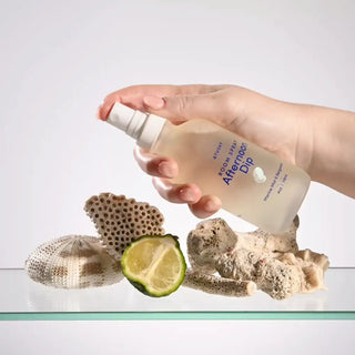 A hand spritzing Afternoon Dip room spray