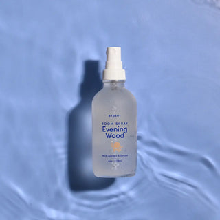 A bottle of Evening Wood Room Spray on a watery background