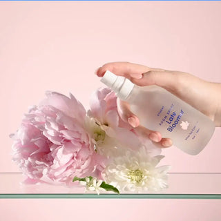 A hand spritzing late bloomer room spray