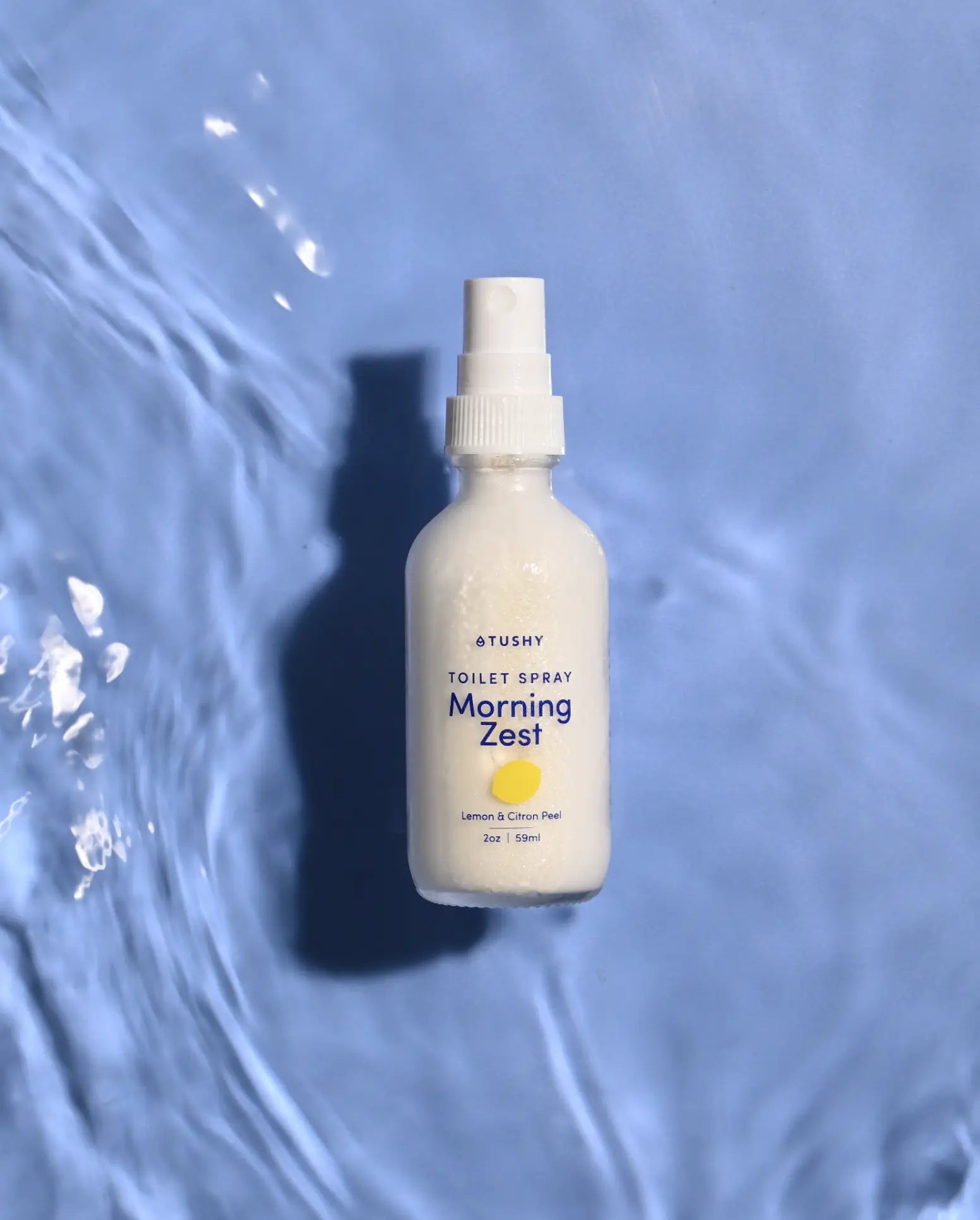 TUSHY Room Spray on a watery background
