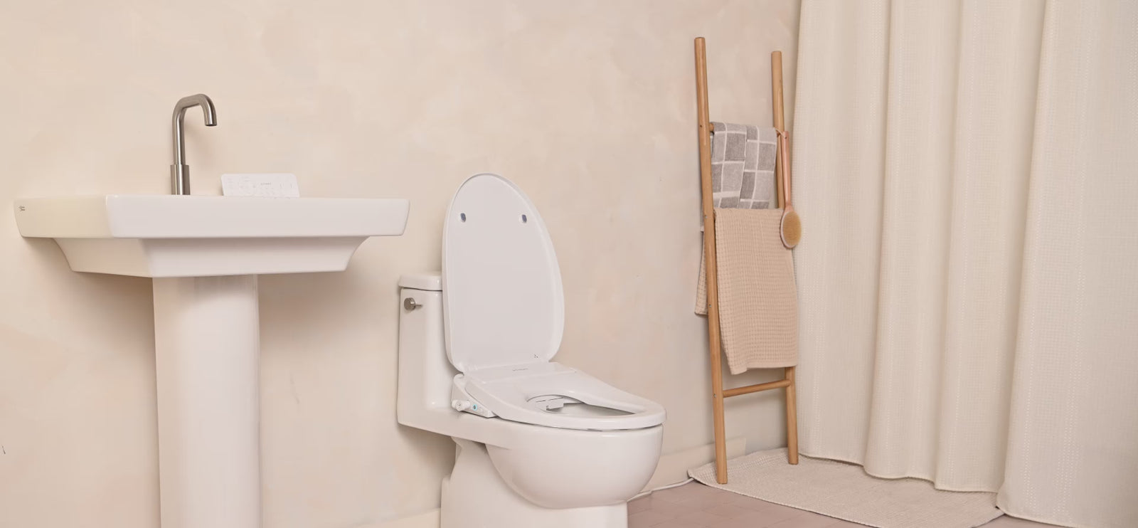 Cloud+ by TUSHY video.  A man walks into a bathroom, sits down, picks up and looks at the remote. Water sprays into the toilet. He smiles. A dolly shot of the bidet with a nightlight on